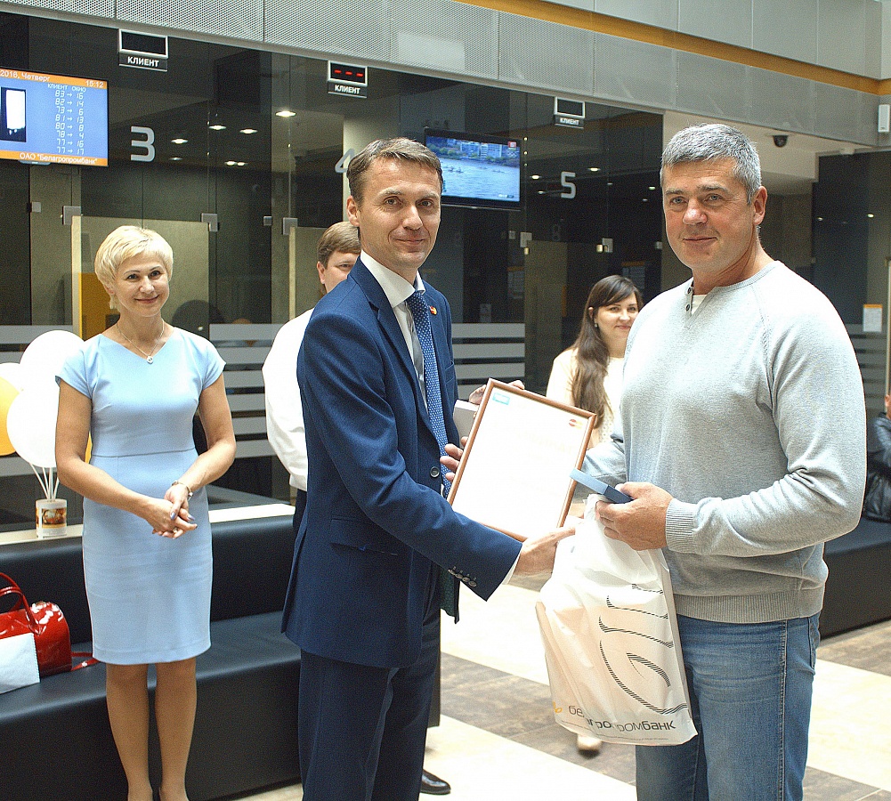 Вице-президент MasterCard в Беларуси Сергей Коптик (слева) вручает памятные подарки тысячному клиенту Виктору Логвиновичу (справа)